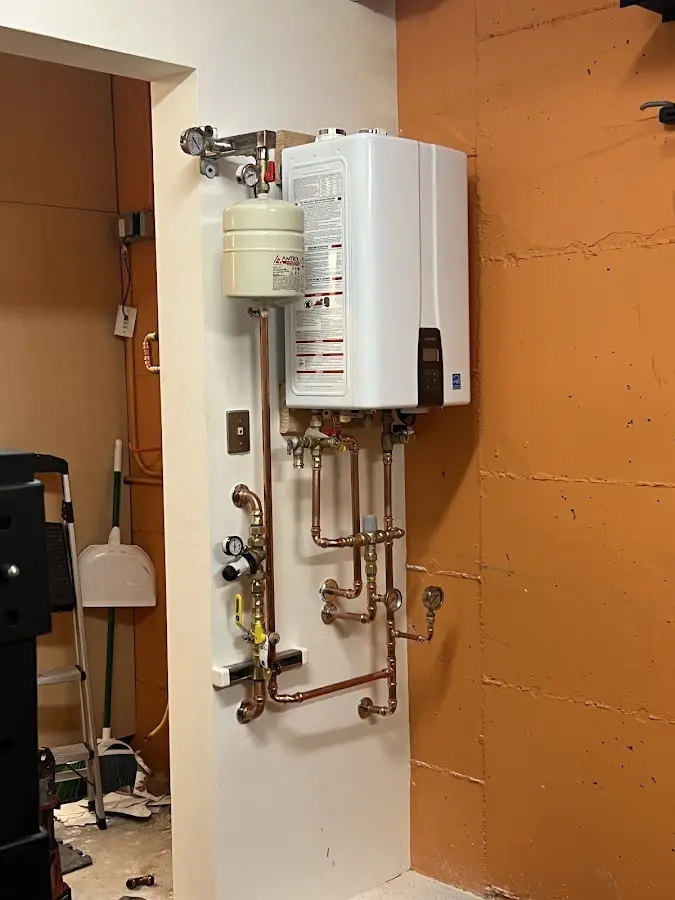 Plumbing technician inspecting water heater connections in Hellertown